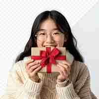 PSD une mignonne fille asiatique avec un cadeau sur un fond blanc isolé