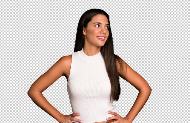 Mirando feliz alegre y confiado sonriendo con orgullo y mirando a un lado con ambas manos en las caderas