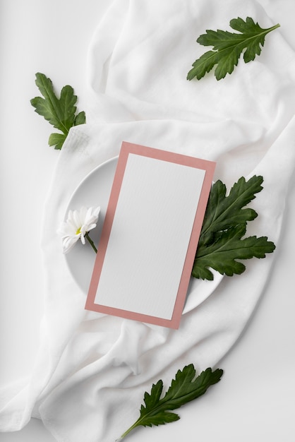 PSD mise à plat de la disposition de la table avec maquette de menu de printemps sur une assiette avec des feuilles et des fleurs