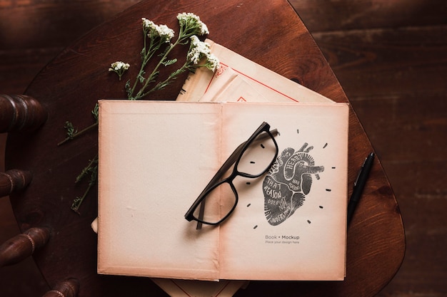 Mise à plat de livres avec des lunettes et des fleurs