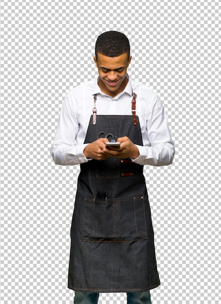 Mladý afroamerický holič posílá zprávu mobilem