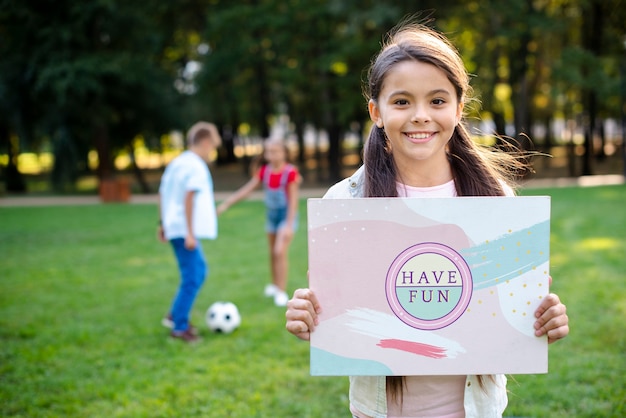 Moça no parque que guarda o sinal com mensagem positiva