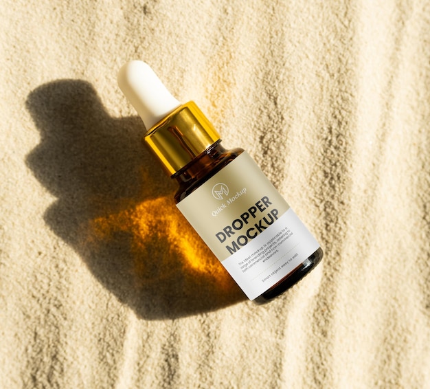 PSD mock up bouteille de sérum en verre ambre sur fond de sable pipette goutte à goutte cosmétique facial en lumière du soleil tendance style minimaliste