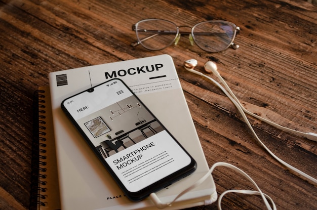 Mock-up di libri per smartphone e riviste su sfondo di legno