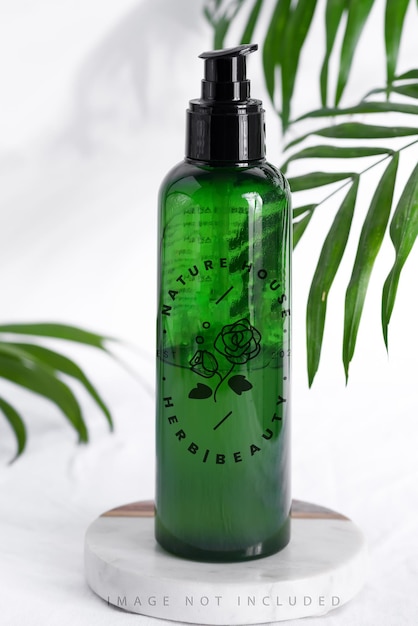 mockup bottiglia di plastica verde con foglie tropicali di palma sempreverdi copia spazio