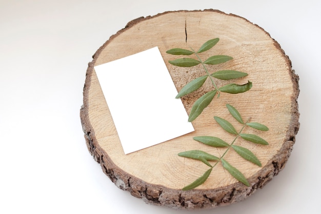 Mockup della carta di nozze su uno sputo di legno con le foglie dei pistacchi