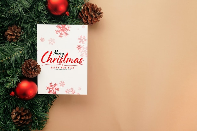 Mockup di biglietto di auguri di buon Natale con decorazioni di foglie di pino