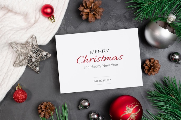 Mockup di biglietto di auguri di Natale con decorazioni festive e rami di pino con coni
