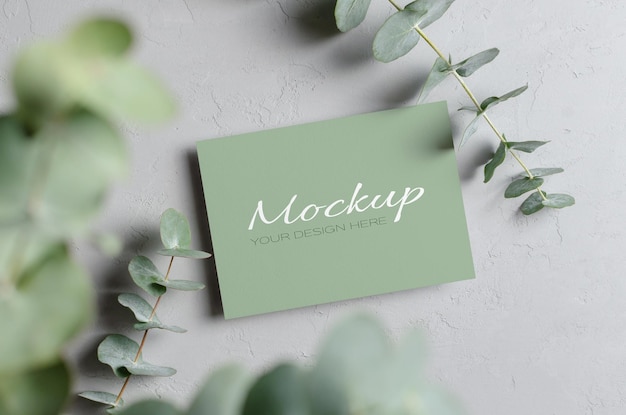 Mockup di carta di invito a nozze con ramoscelli di eucalipto naturale