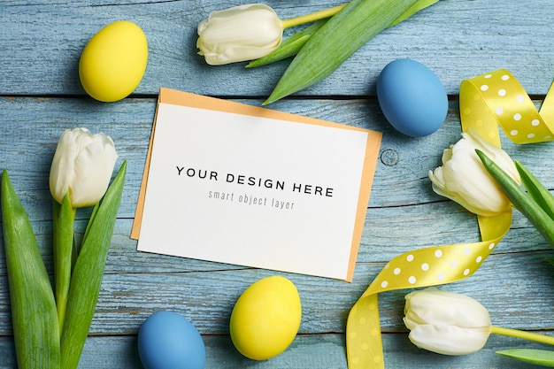 Mockup di cartolina d'auguri di festa di Pasqua con uova colorate, nastri e tulipani