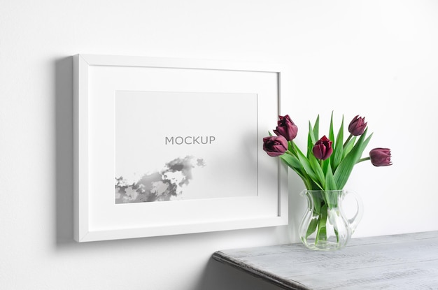 Mockup di cornice orizzontale con fiori di tulipani primaverili all'interno della stanza bianca