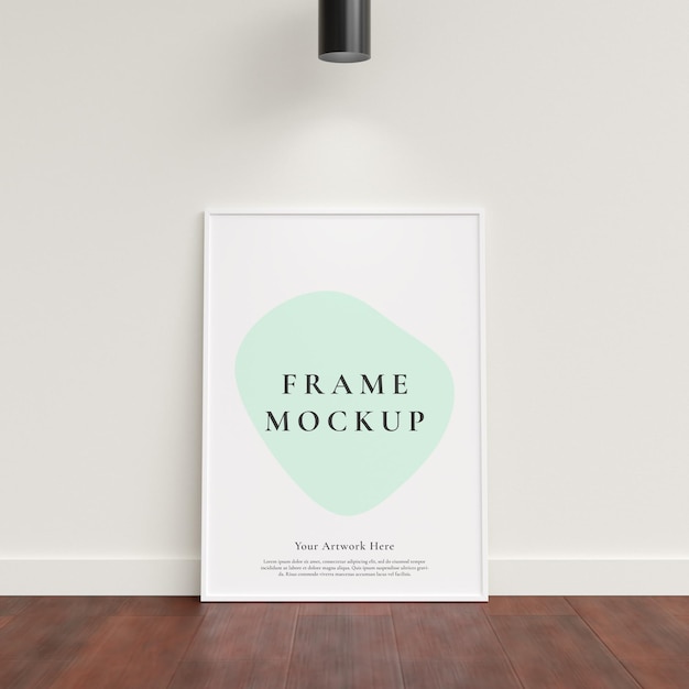Mockup di cornice per foto poster appoggiato al muro bianco sul pavimento di legno