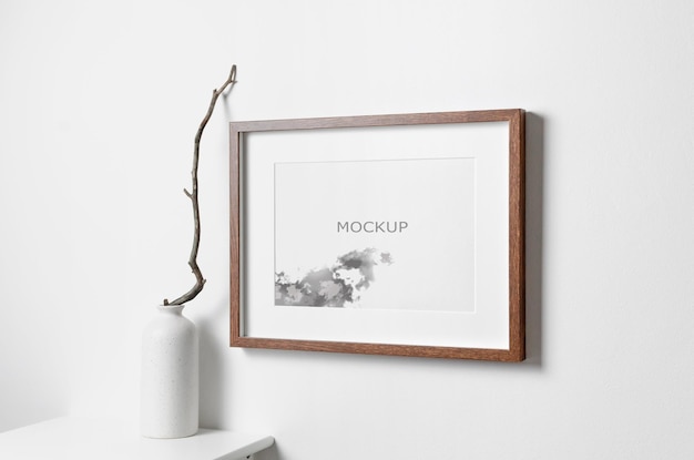 Mockup di cornice per opere d'arte in legno di paesaggio sul muro bianco