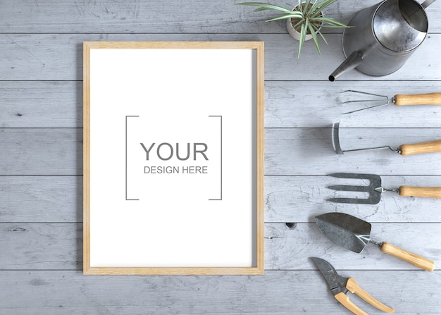 Mockup di cornice sul tavolo di legno con attrezzi da giardinaggio