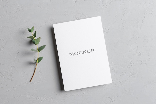 Mockup di invito a nozze o biglietto di auguri con ramoscello di eucalipto fresco