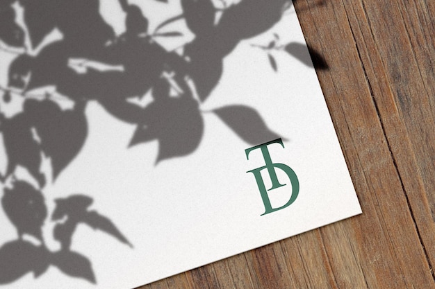 Mockup di logo su foglio di carta su tavola di legno