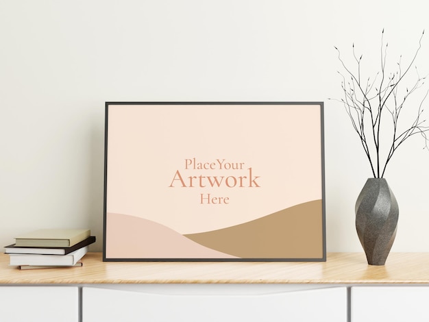 Mockup di poster o cornice per foto nero orizzontale minimalista su tavolo di legno con libri e vaso in una stanza