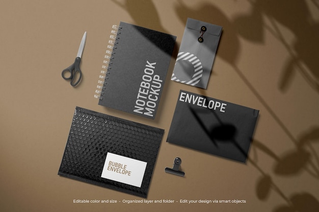 Mockup di taccuino e buste neri di cancelleria di branding