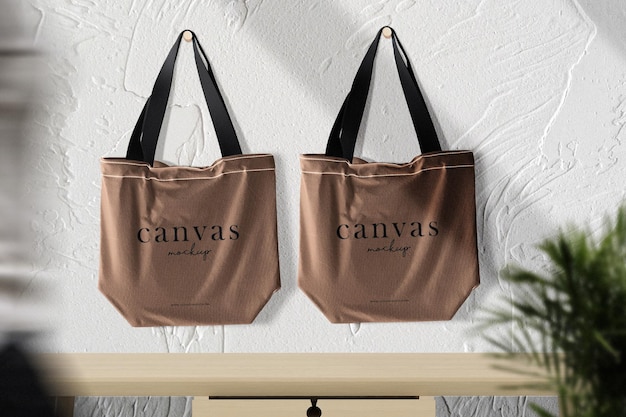 Mockup di tela da appendere pulito e minimale su sfondo di cemento con piante da tavolo in primo piano e persone che camminano