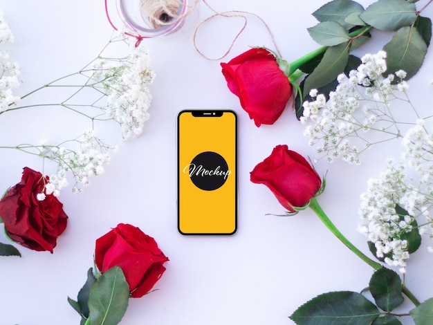 Mockup di telefono con rose su una scrivania