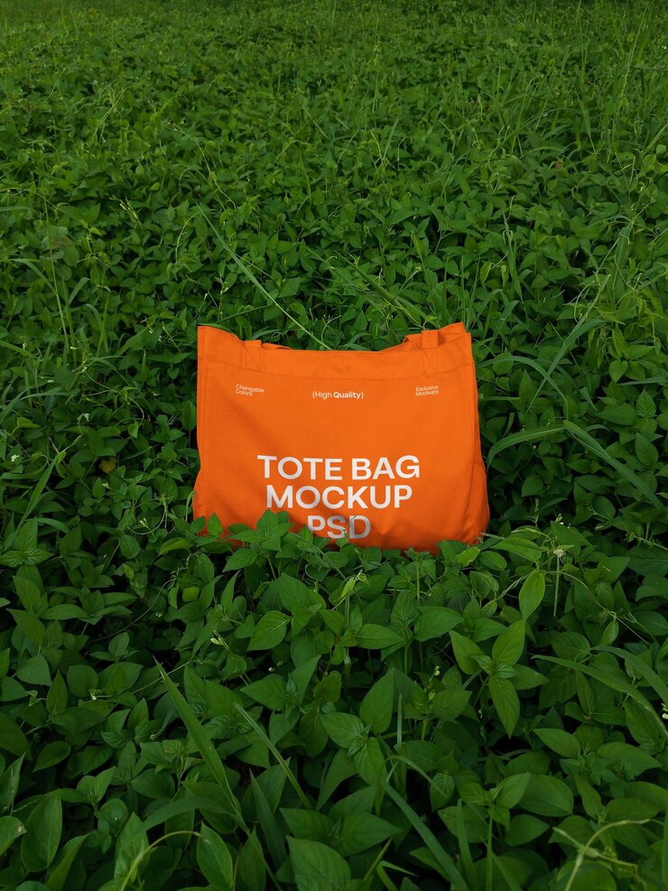 Mockup di una borsa di Tote arancione in un campo verde lussureggiante
