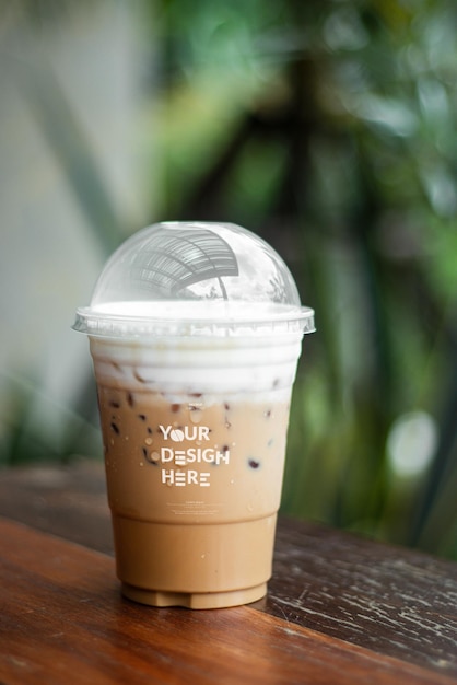 Mockup di una tazza di caffè usa e getta, caffè ghiacciato, cappuccino, latte mocha in tazza di plastica su un tavolo di legno