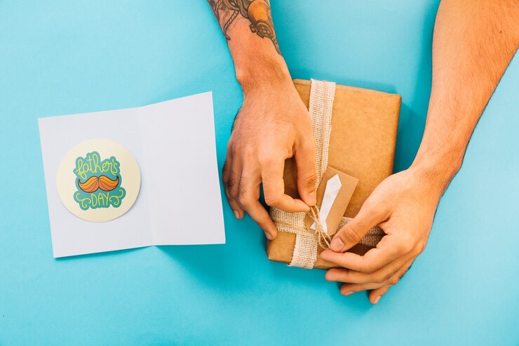 PSD mockup para el día del padre con tarjeta y manos preparando caja de regalo