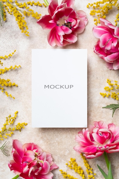 Mockup einer leeren Hochzeits-Einladungskarte mit Frühlingsblumen auf beige Hintergrund