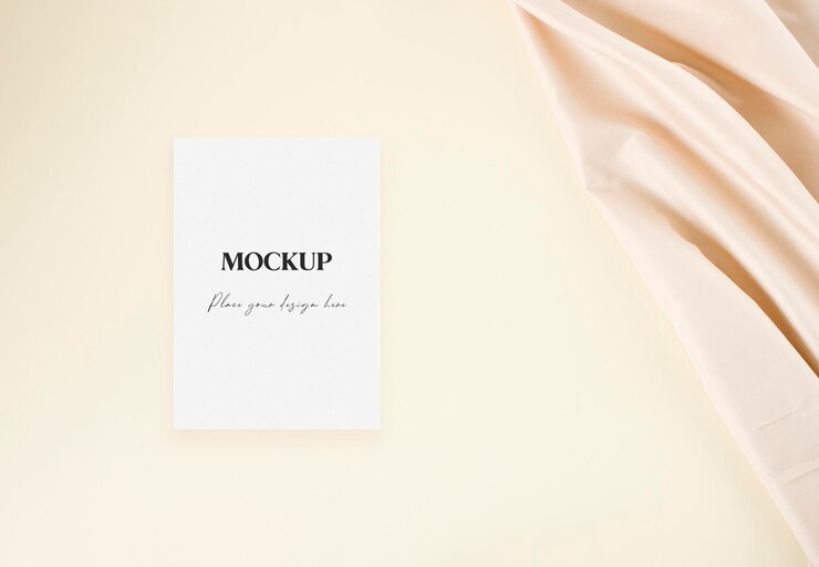 Mockup kartu undangan pernikahan dengan kain nude di atas latar belakang krem