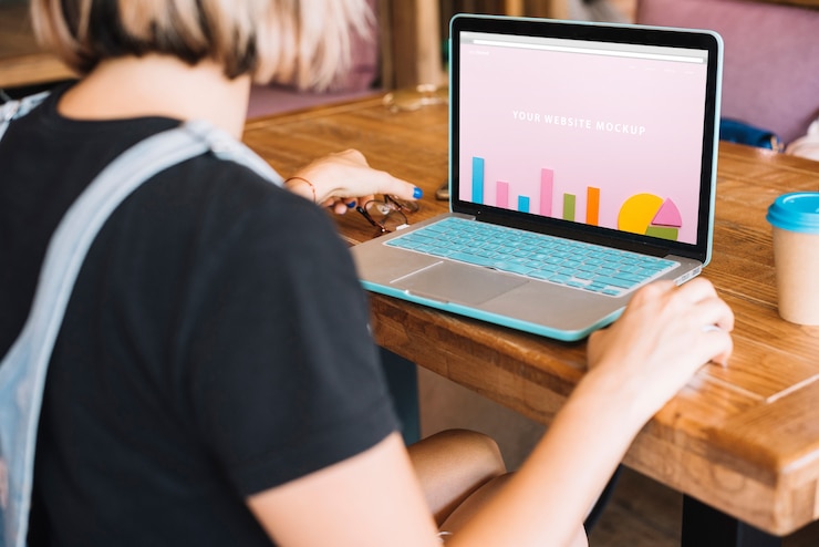 PSD mockup laptop dengan wanita di atas meja kayu