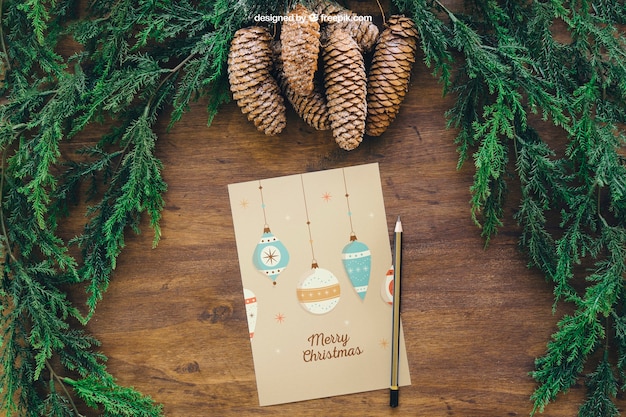 PSD mockup de navidad con pinos de piña y tarjeta de felicitación