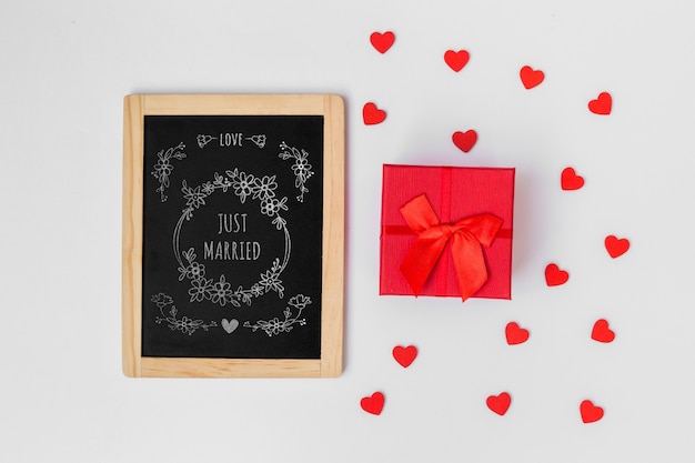 PSD mockup de pizarra al lado de regalo para san valentin