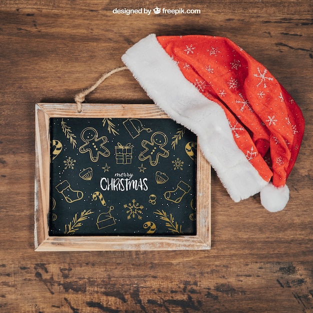 Mockup de pizarra y gorro con diseño de navidad