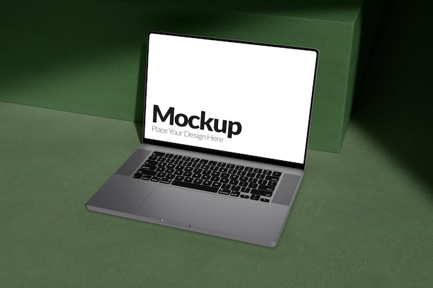 Mockup de portátil en una superficie verde con pantalla en blanco