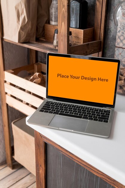 Mockup de PSD de la computadora portátil de pantalla naranja en la mesa