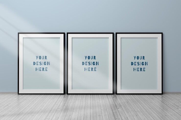 Mockup psd modificabile con tre cornici verticali nere vuote in formato A4 in piedi sul pavimento di legno accanto al muro