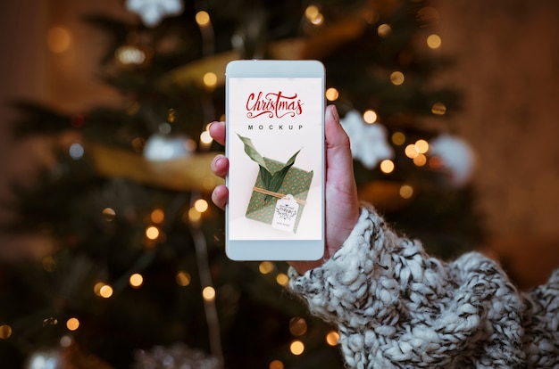 Mockup de rebajas de navidad con mano sujetando smartphone