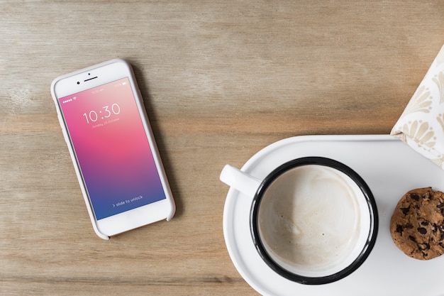 Mockup de smartphone al lado de café