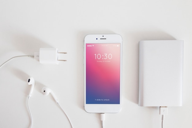 Mockup de smartphone con cable de cargar y auriculares