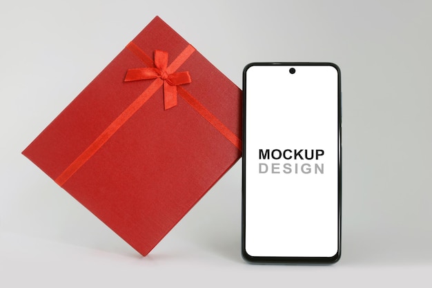 Mockup de smartphone con caja de regalo roja