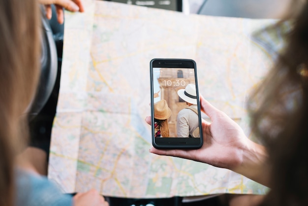 Mockup de smartphone con chicas mirando a mapa