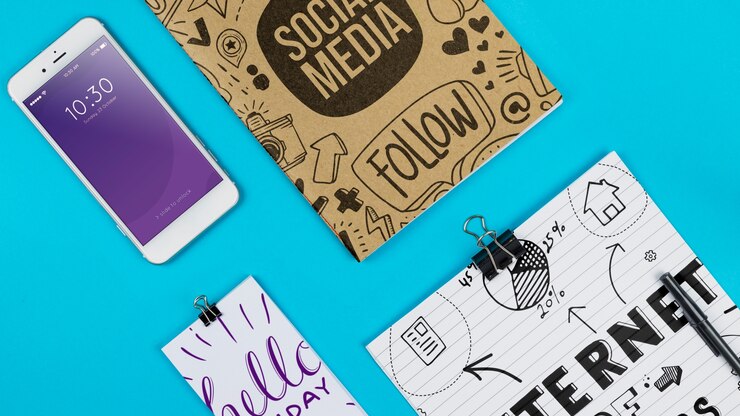 PSD mockup smartphone dengan perlengkapan kantor di atas meja
