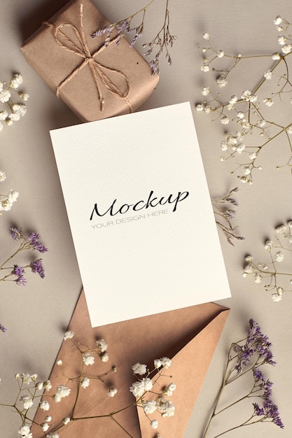 Mockup stazionario per biglietti di auguri con busta, confezione regalo e decorazioni di fiori secchi