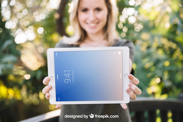 Mockup de tablet con mujer en naturaleza