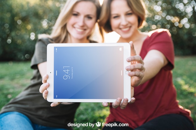 PSD mockup de tablet con mujeres en la naturaleza