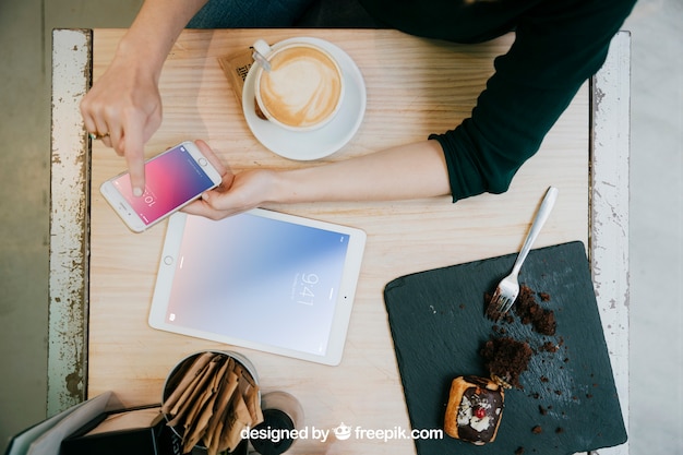 Mockup de tablet y smartphone con vista superior de mesa