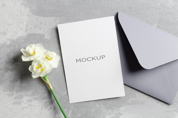 Mockup de tarjeta de invitación con sobre y flores de narcisos