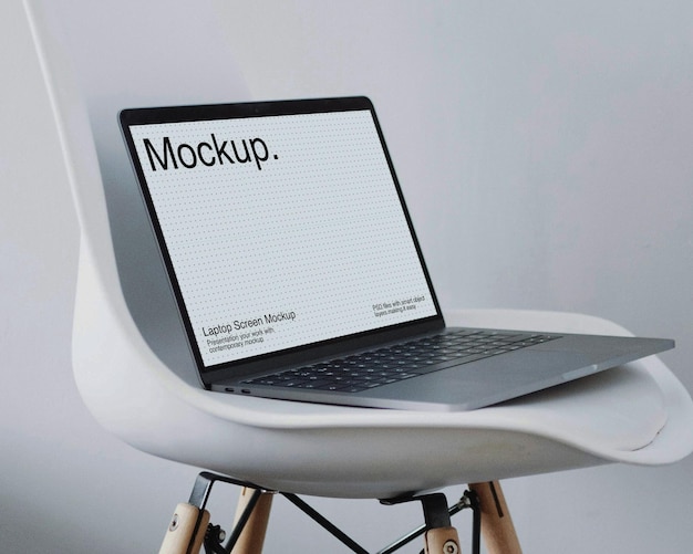Modèle d'ordinateur portable sur une chaise blanche
