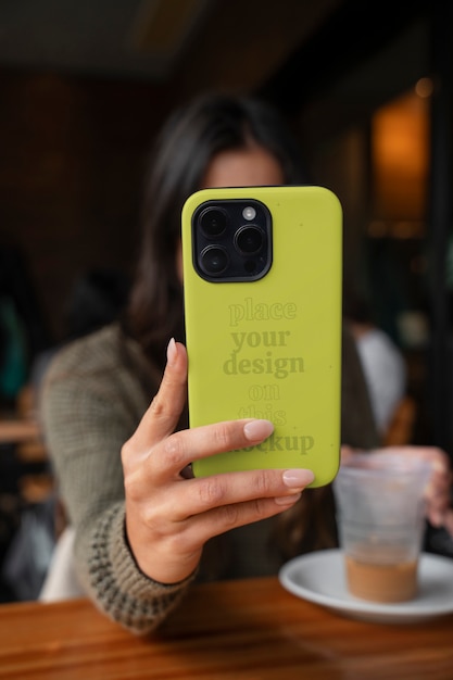 Modèle tenant un smartphone avec un boîtier cool