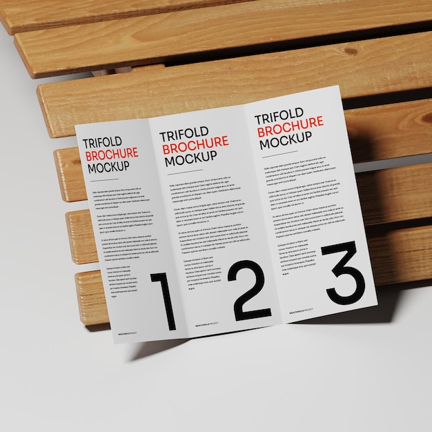 Modello di opuscolo triplo con sfondo di tavolo di legno
